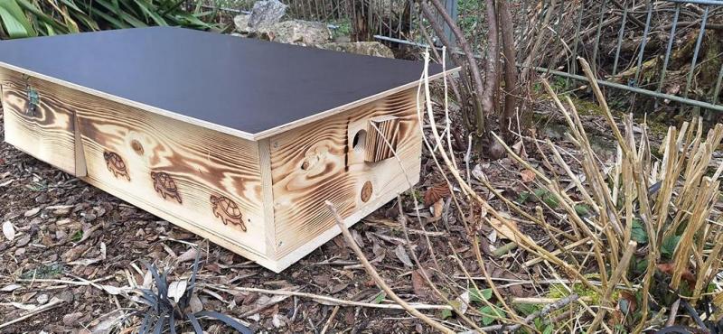 Entrance of Woidherz XXL tortoise house with sliding wooden door